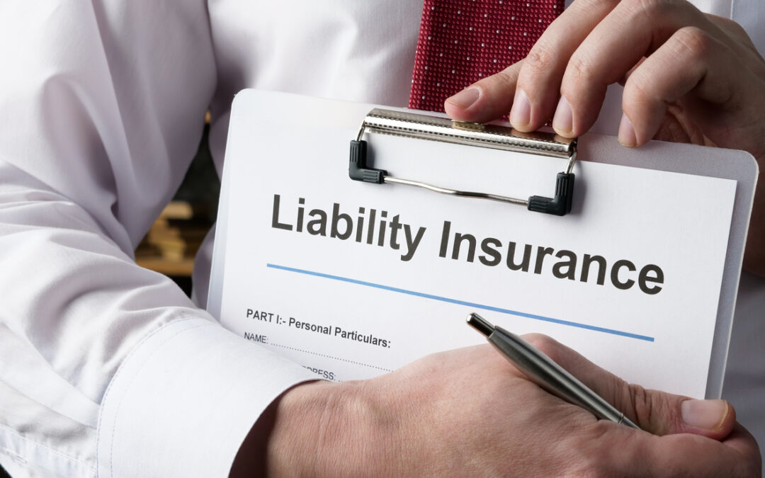 Hands hold liability insurance policy and pen.